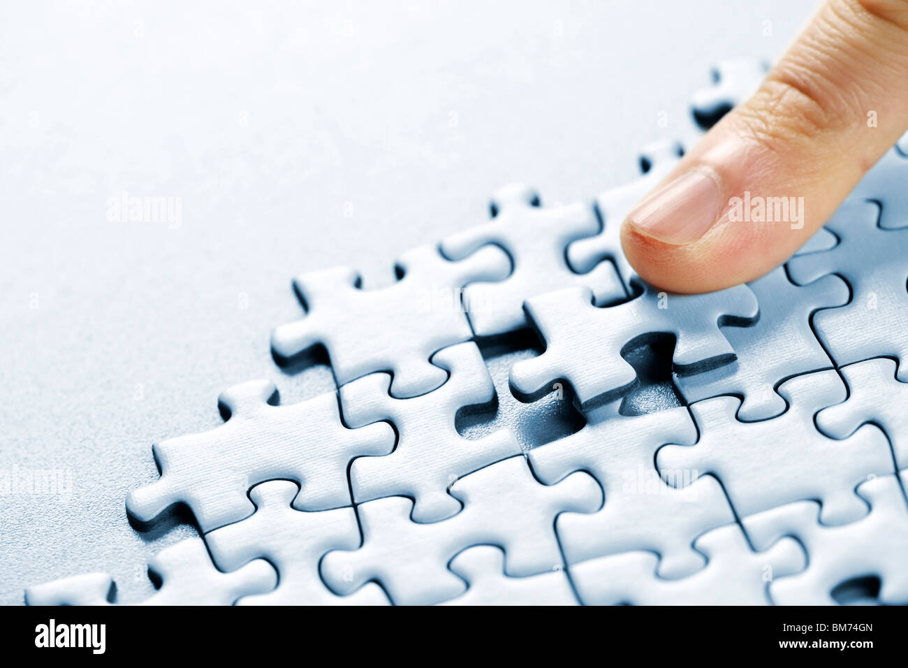 Finger schieben fehlende Puzzleteil einrastet Stockfoto