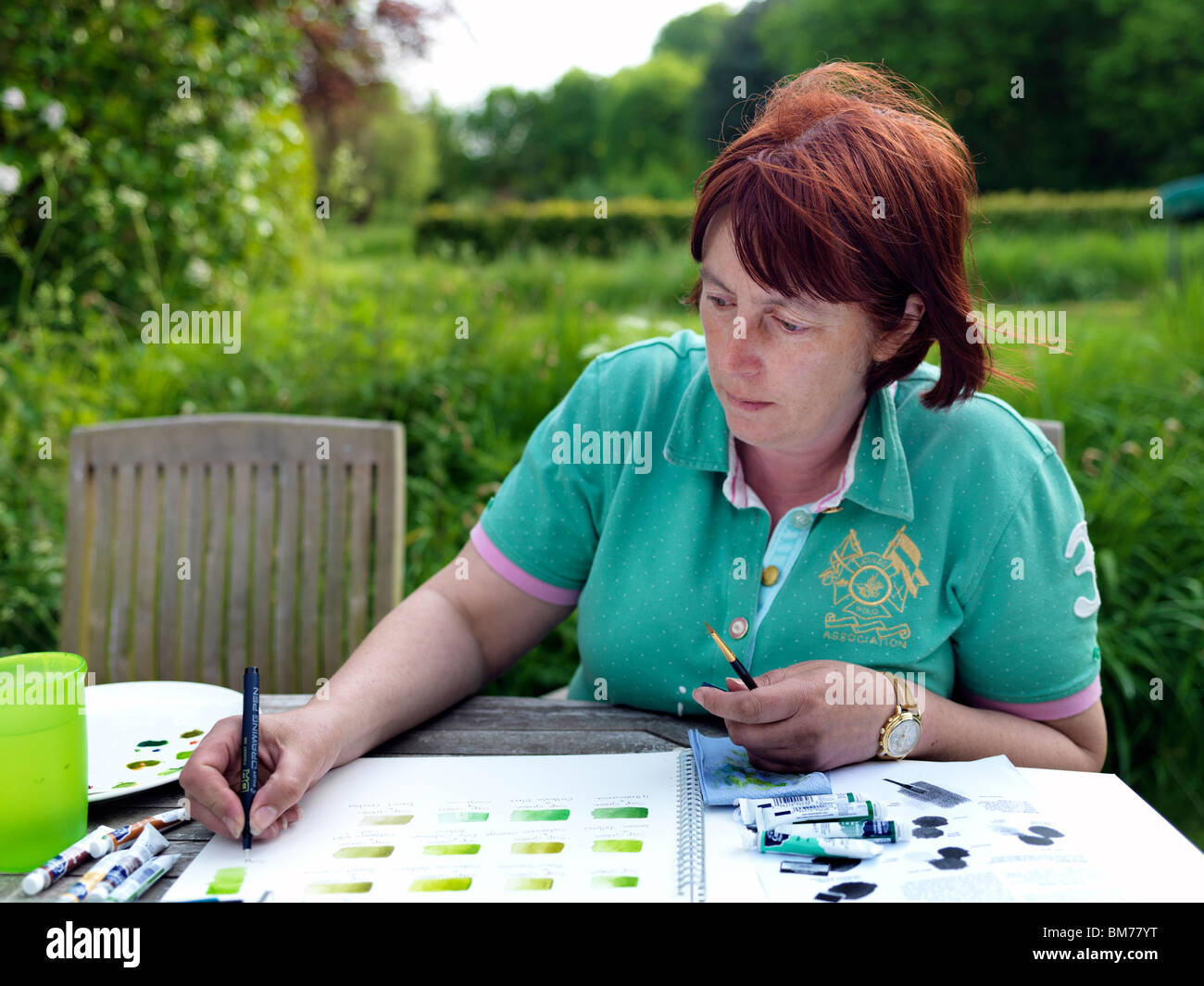 Frau in einem englischen Garten im Frühling malt. Stockfoto