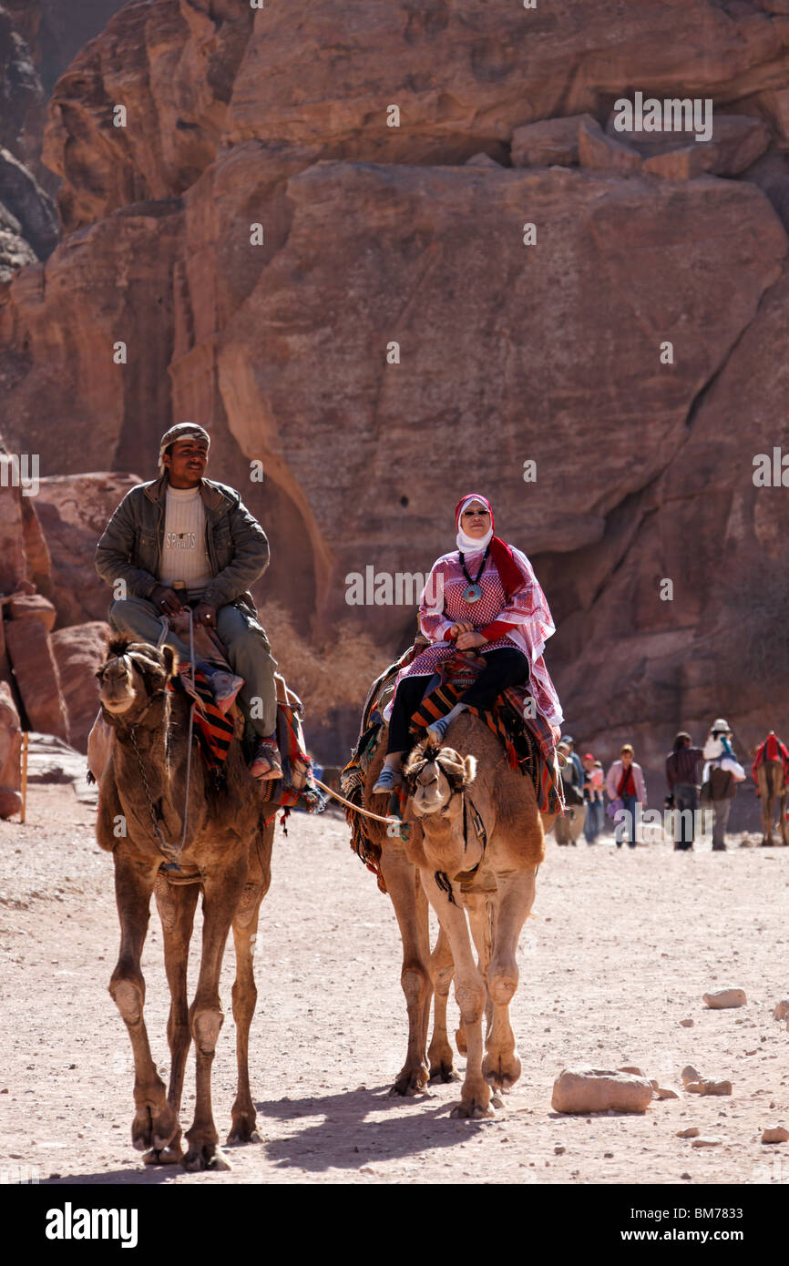 Auf Kamel zurück nimmt eine Frau einen entspannenden Blick auf Petra Stockfoto