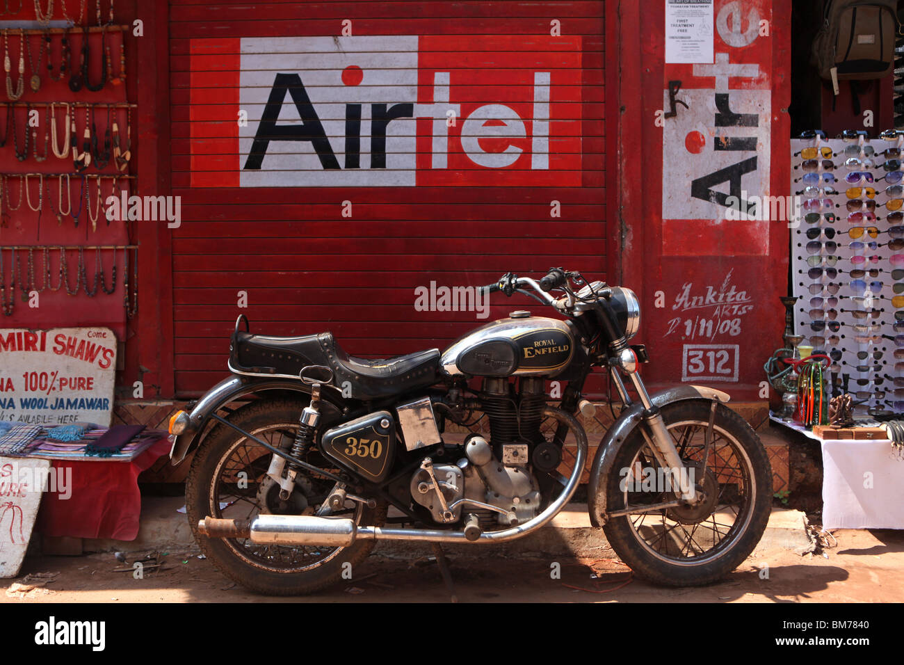 Royal Enfield Motorrad geparkt vor einem Handy-Shop, wie in Arambol in Goa, Nordindien zu sehen. Stockfoto