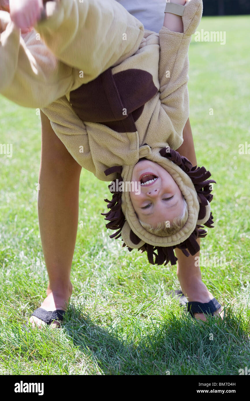 Ein Kleiner Junge In Einem Lowen Kostum Kopfuber Gehalten Von Einem Erwachsenen Stockfotografie Alamy