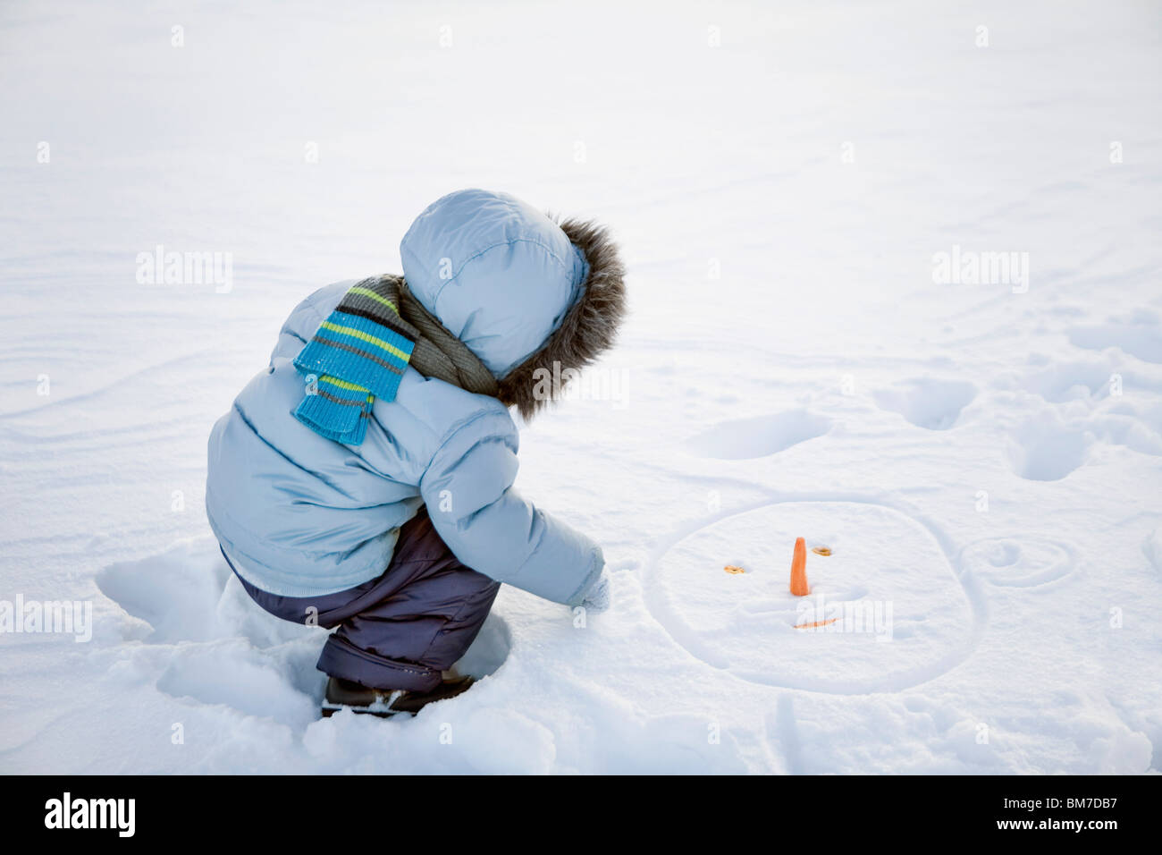 Ein Junge spielt im Schnee Stockfoto