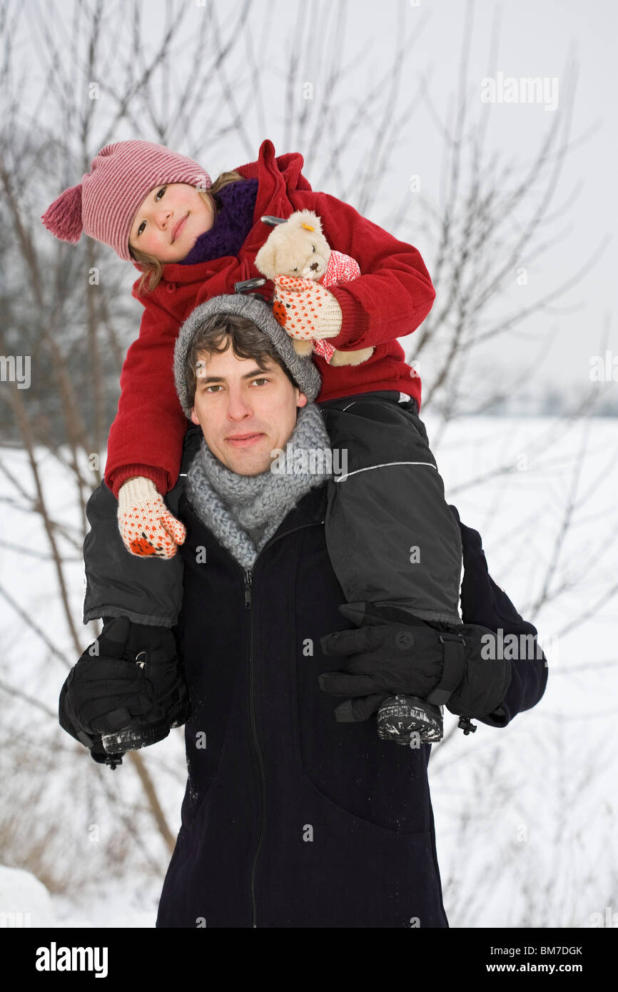 Ein Mann, der seine Tochter auf seinen Schultern trägt Stockfoto