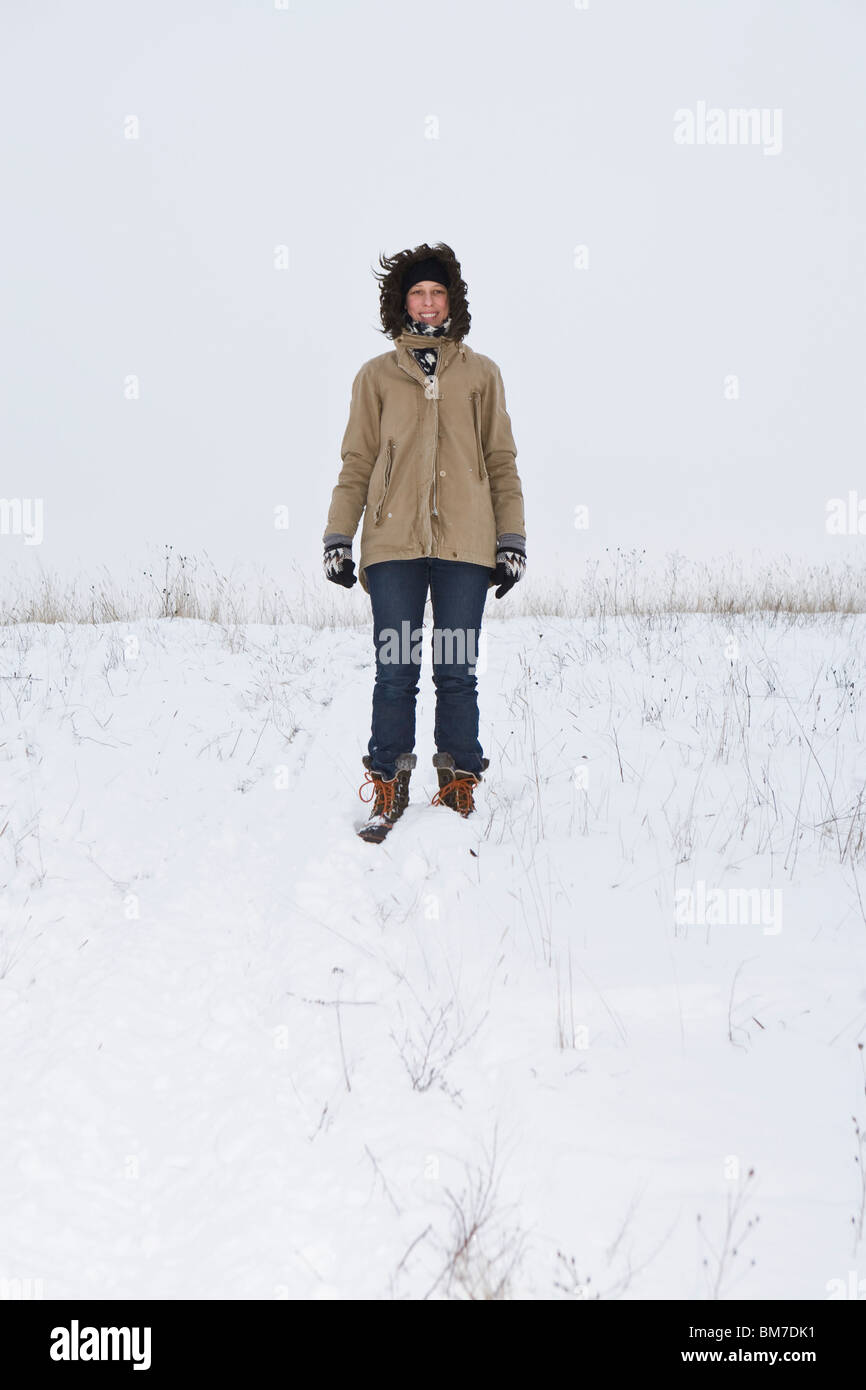 Eine Frau stand auf einem schneebedeckten Hügel, Porträt Stockfoto