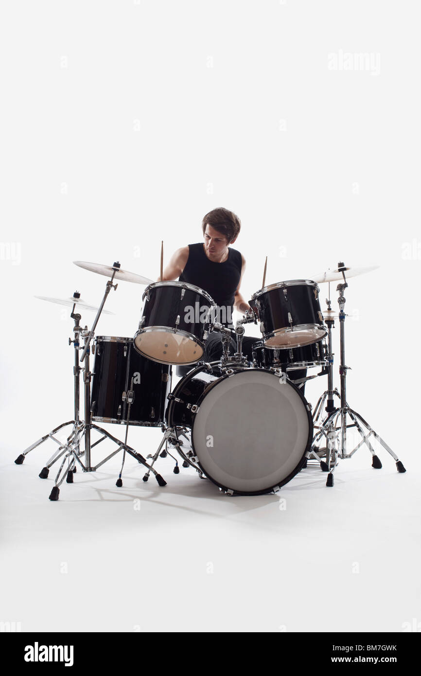Ein Mann am Schlagzeug durchführen, Studio gedreht, weißen Hintergrund beleuchtet zurück Stockfoto