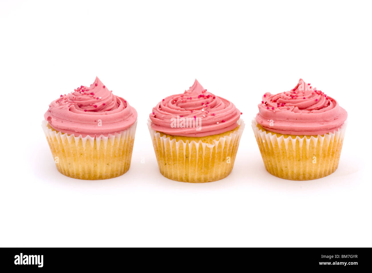 drei rosa Tasse Kuchen auf weißem Hintergrund Stockfoto