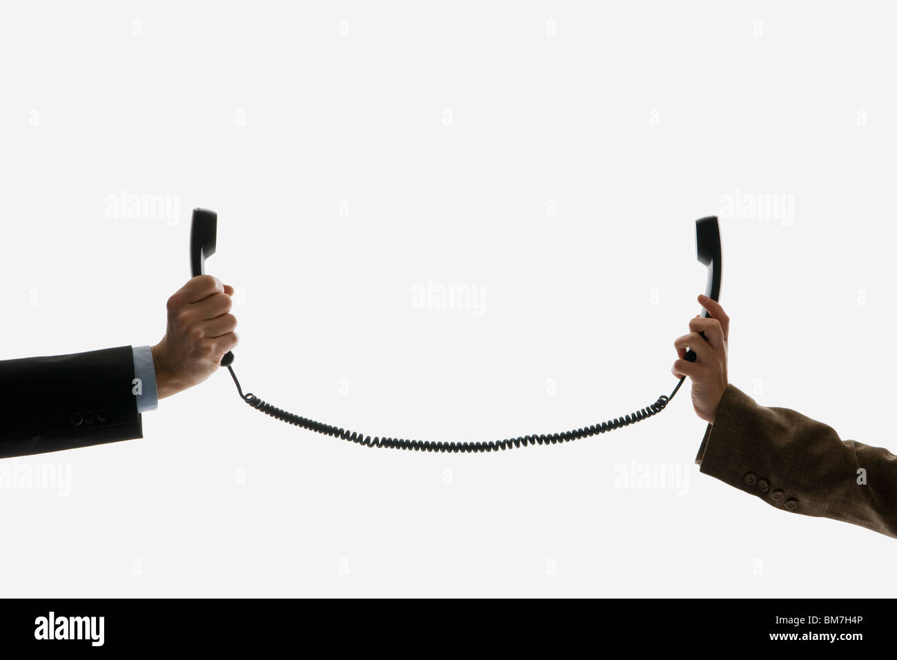 Zwei Geschäftsleute halten Telefon Empfänger verbinden mit dem gleichen Kabel Stockfoto