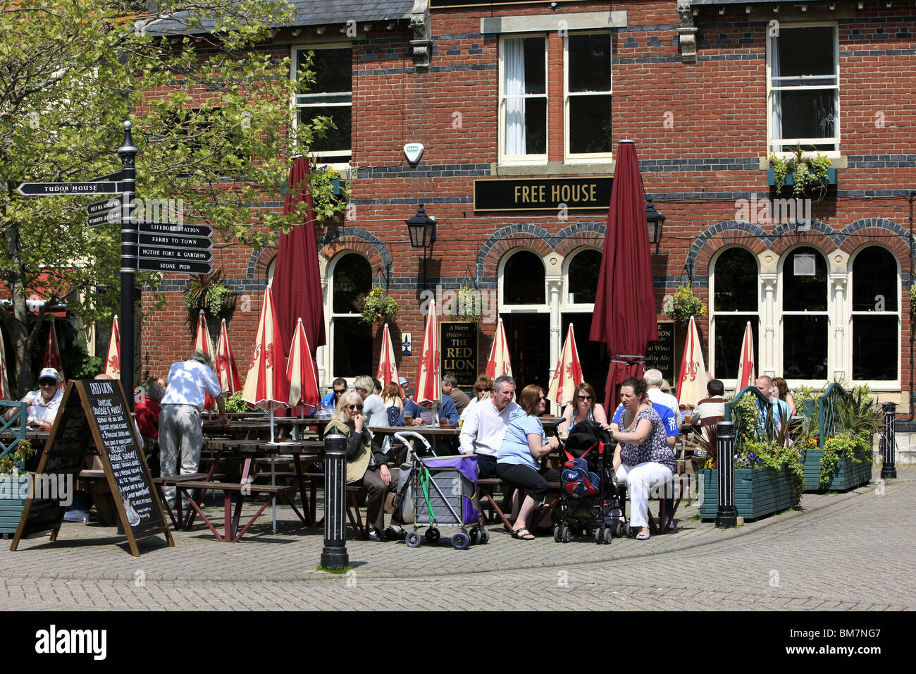 Leute sitzen außerhalb der Red Lion Pub in Weymouth genießen die Sonne und ein Pub-Mittagessen Stockfoto