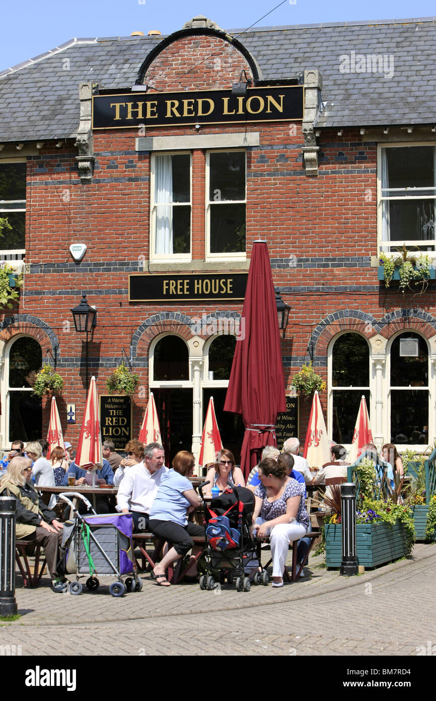 Leute sitzen außerhalb der Red Lion Pub in Weymouth genießen die Sonne und ein Pub-Mittagessen Stockfoto