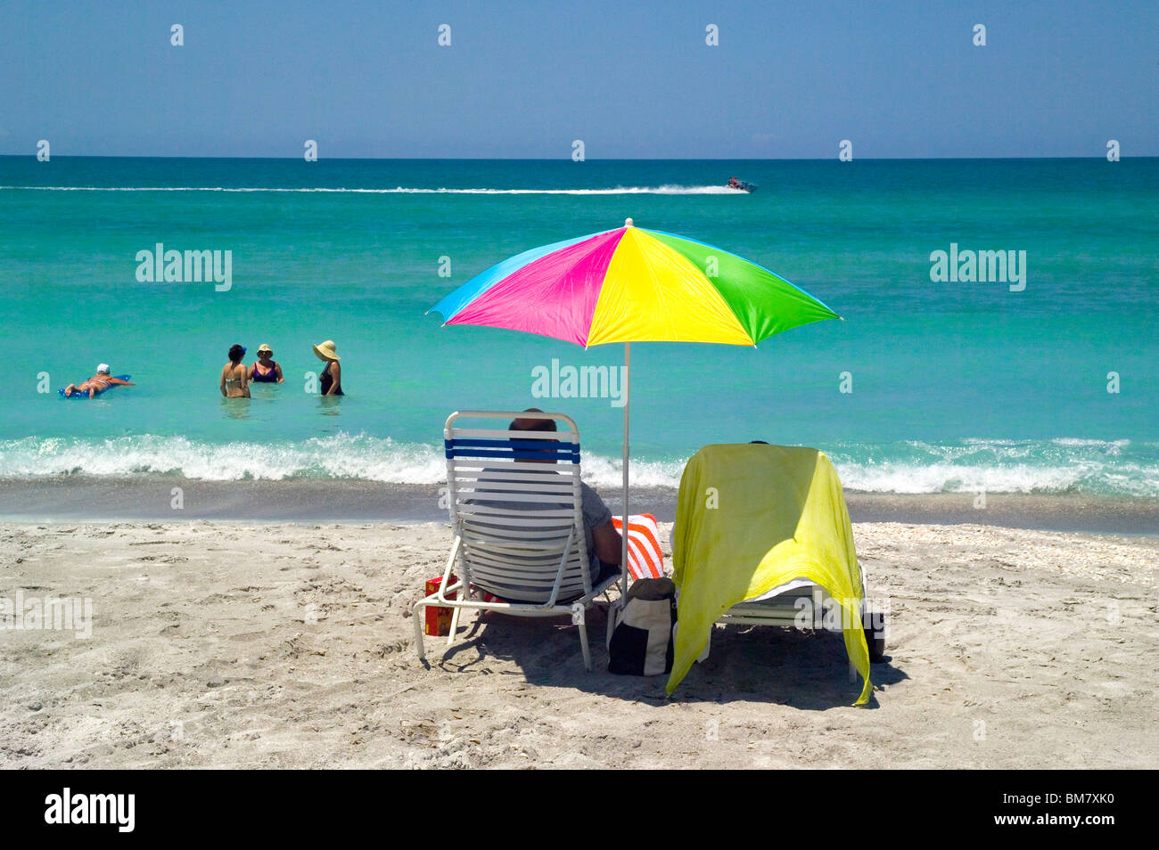 Urlauber am Ufer sehen Sie ihre Freunde ein Sonnenbad in den warmen Gewässern des Golf von Mexiko Türkis entlang der Longboat Key Beach in Sarasota, Florida, USA. Stockfoto