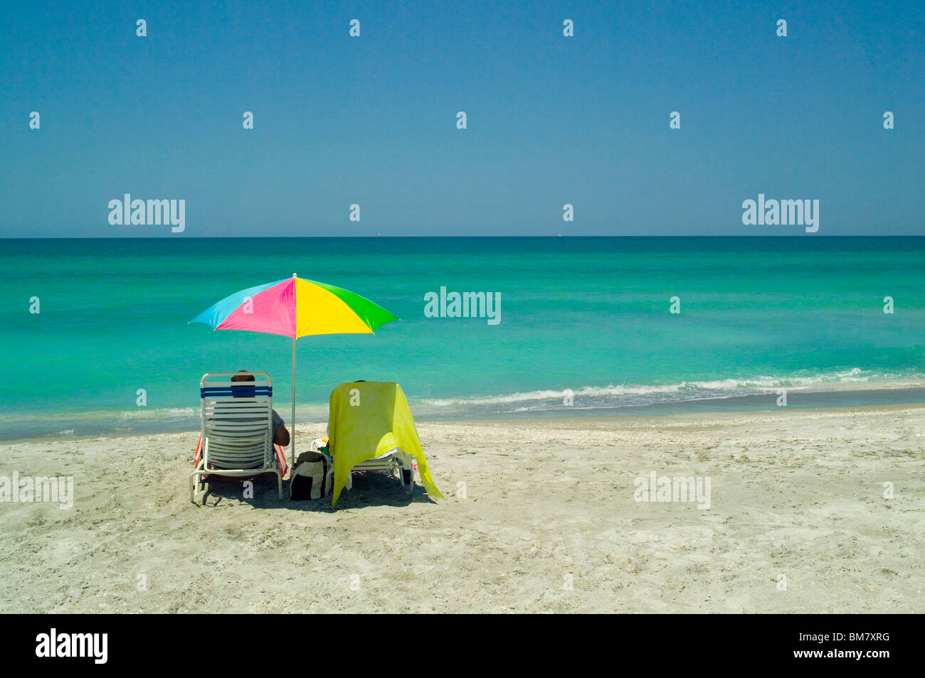 Urlauber entspannen Sie mit einem ruhigen Blick auf den unberührten Golf von Mexiko türkisfarbenen Gewässern entlang der Longboat Key Beach in Sarasota, Florida, USA. Stockfoto