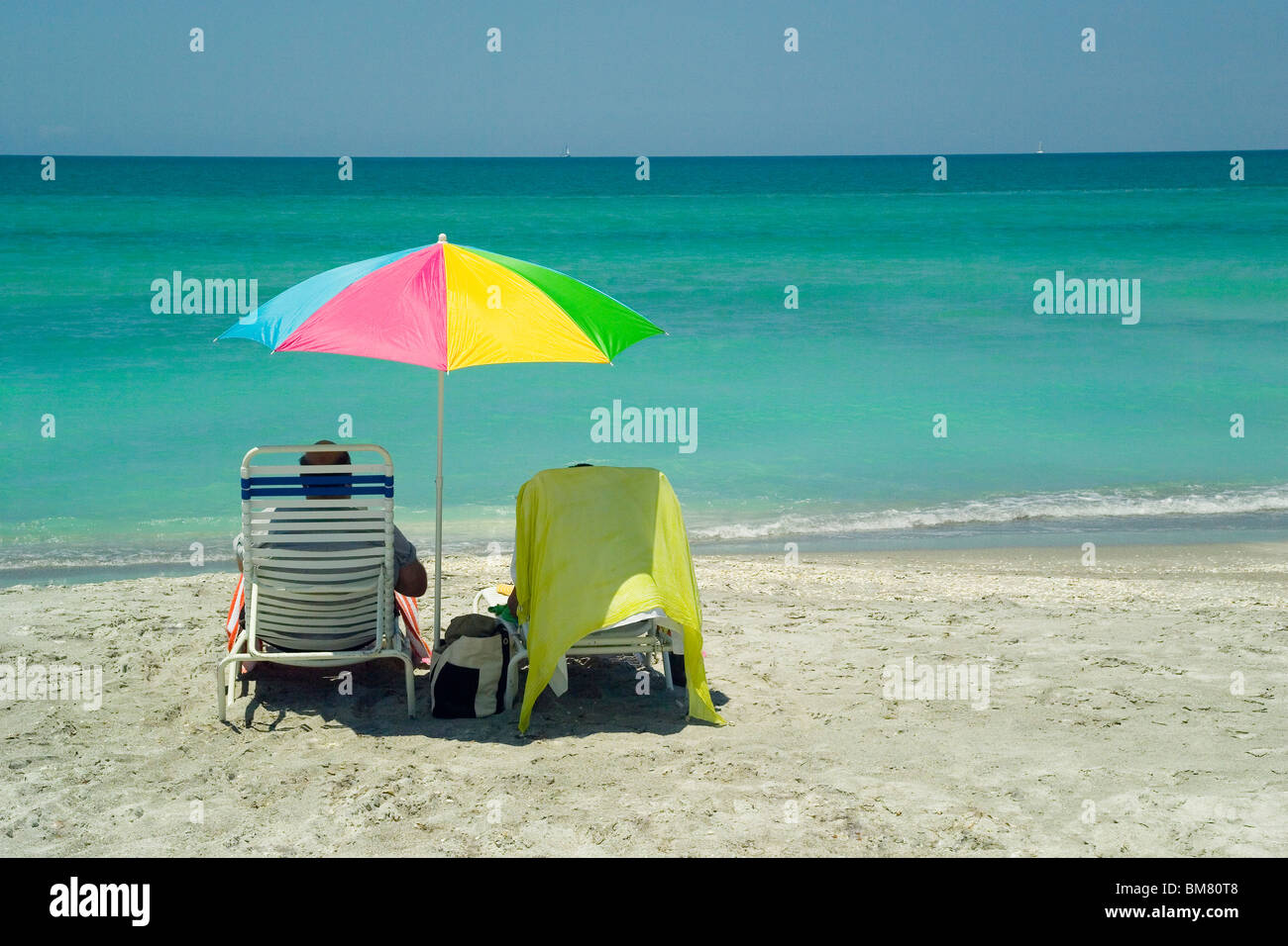Urlauber entspannen Sie mit einem ruhigen Blick auf den unberührten Golf von Mexiko türkisfarbenen Gewässern entlang der Longboat Key Beach in Sarasota, Florida, USA. Stockfoto