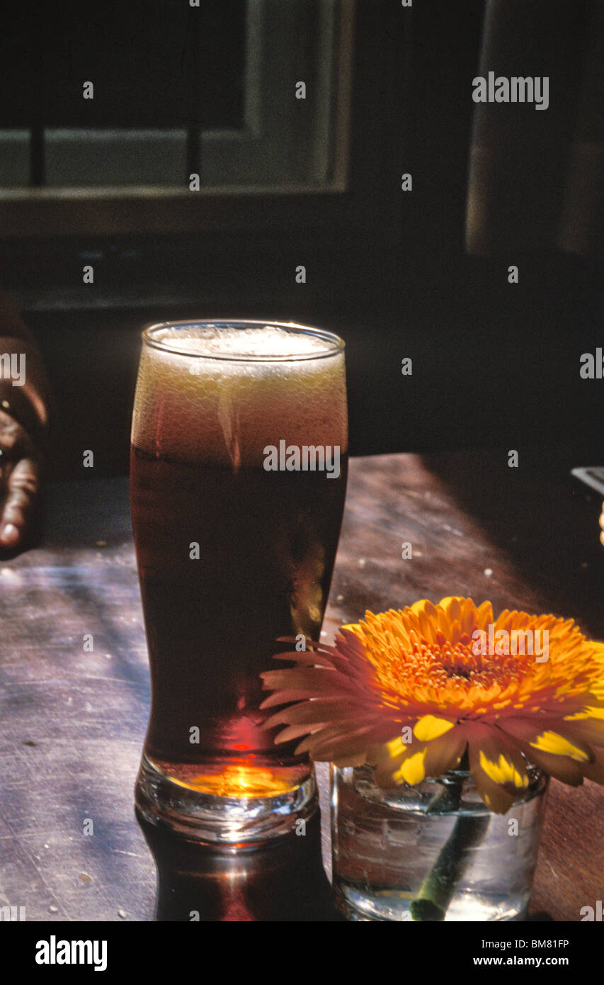 Durstlöscher, Tisch Glas Bier am Nachmittag Schatten dunkel Pilsner. Stockfoto