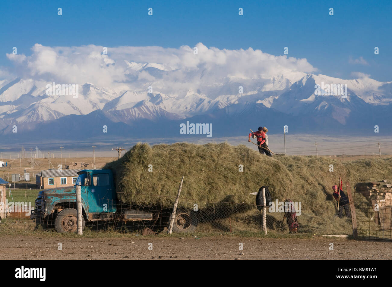 Bauern arbeiten, Berge von Sary Tash im Hintergrund, Kirgisistan Stockfoto