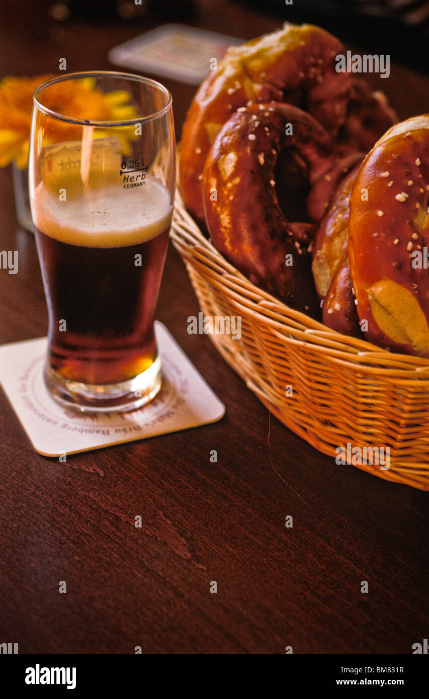 Durstlöscher, Tisch Glas Bier am Nachmittag Schatten dunkel Pilsner. Wicker  Korb weiche Brezeln Stockfotografie - Alamy