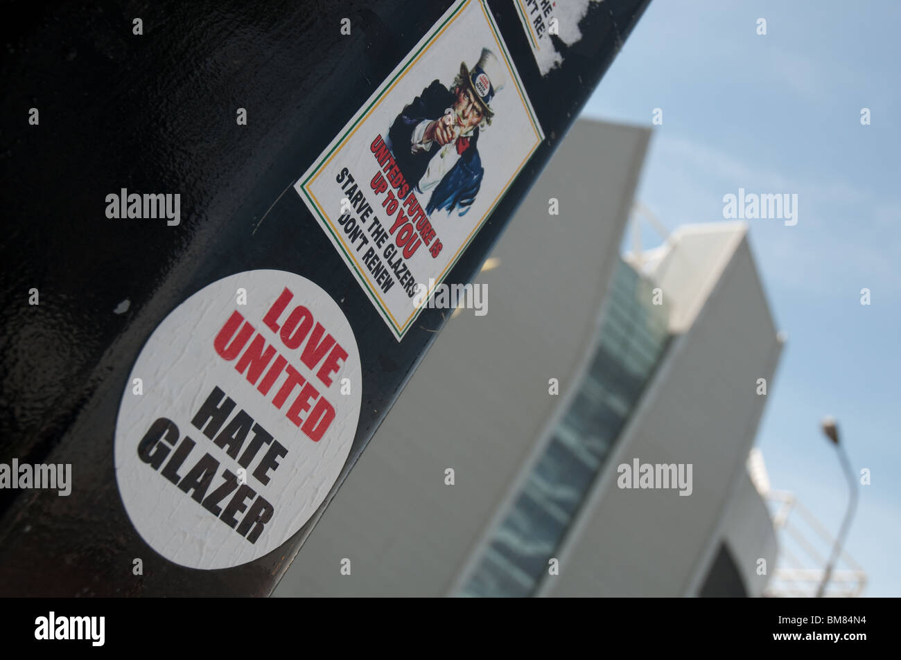 Liebe vereint hasse Glazer Protest-Sticker mit Old Trafford im Hintergrund. Stockfoto