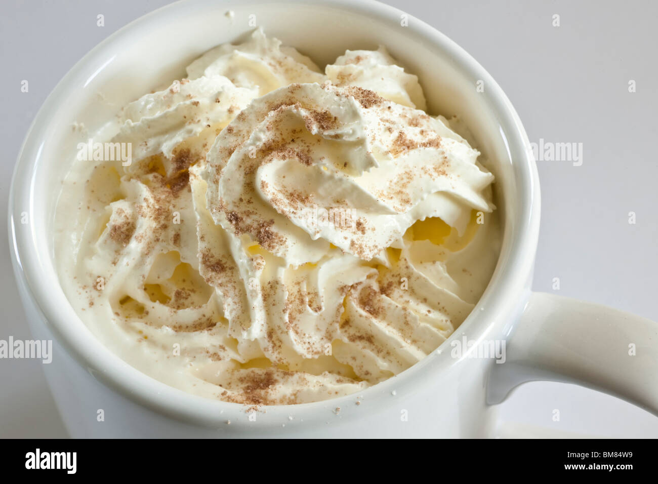 Cappuccino cremig Kaffee oben in einem mittleren weißen einfachen Becher Stockfoto