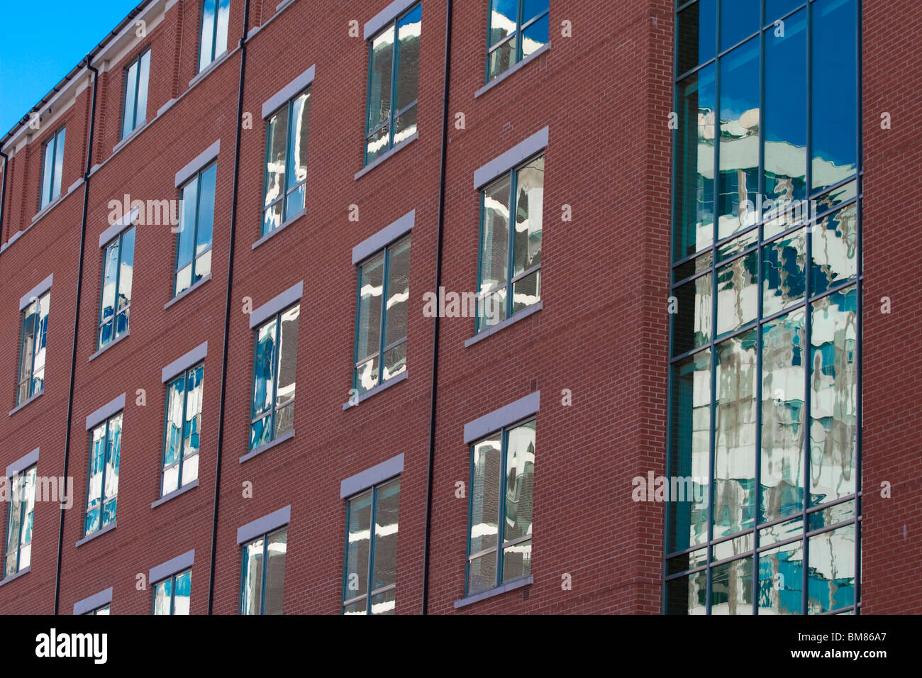 Moderne Wohnungen mit Reflexionen von Altbauten und den strahlend blauen Himmel in Nottingham England UK Stockfoto