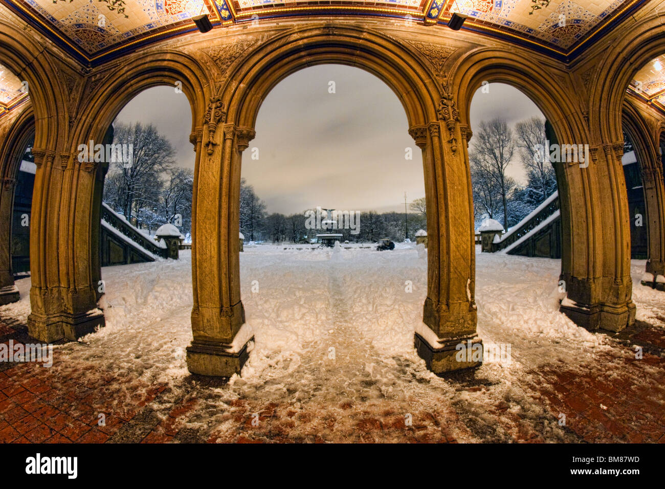 Fish eye Blick auf Bethesda Brunnen im New Yorker Central Park gesehen durch die Bögen des Bethesda Terrasse in einer verschneiten Nacht Stockfoto