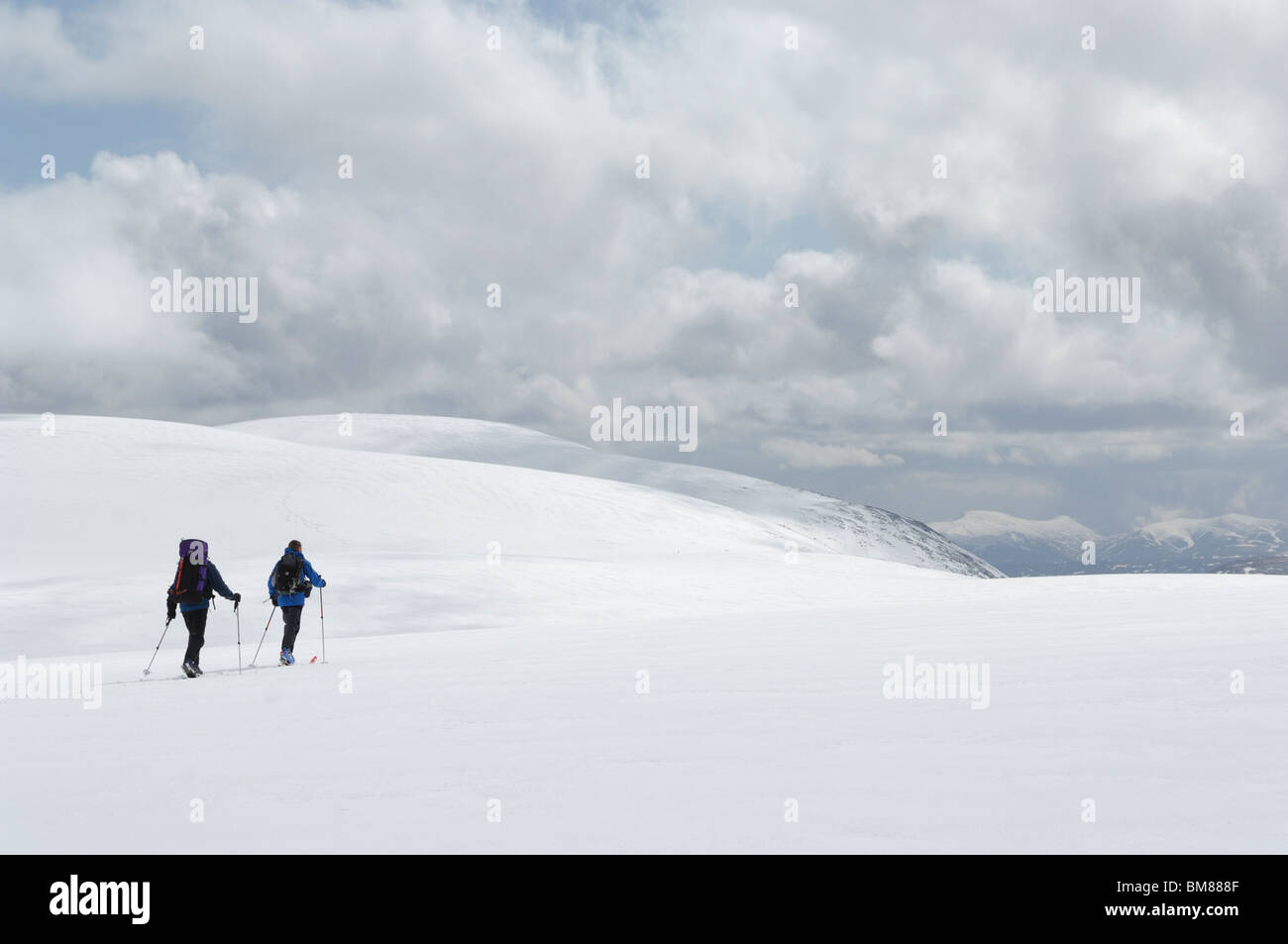 Zwei Männer Ski Alpin über den Schnee bedeckt Cairngorm Plateau in Richtung Gipfel von Ben Macdui Stockfoto