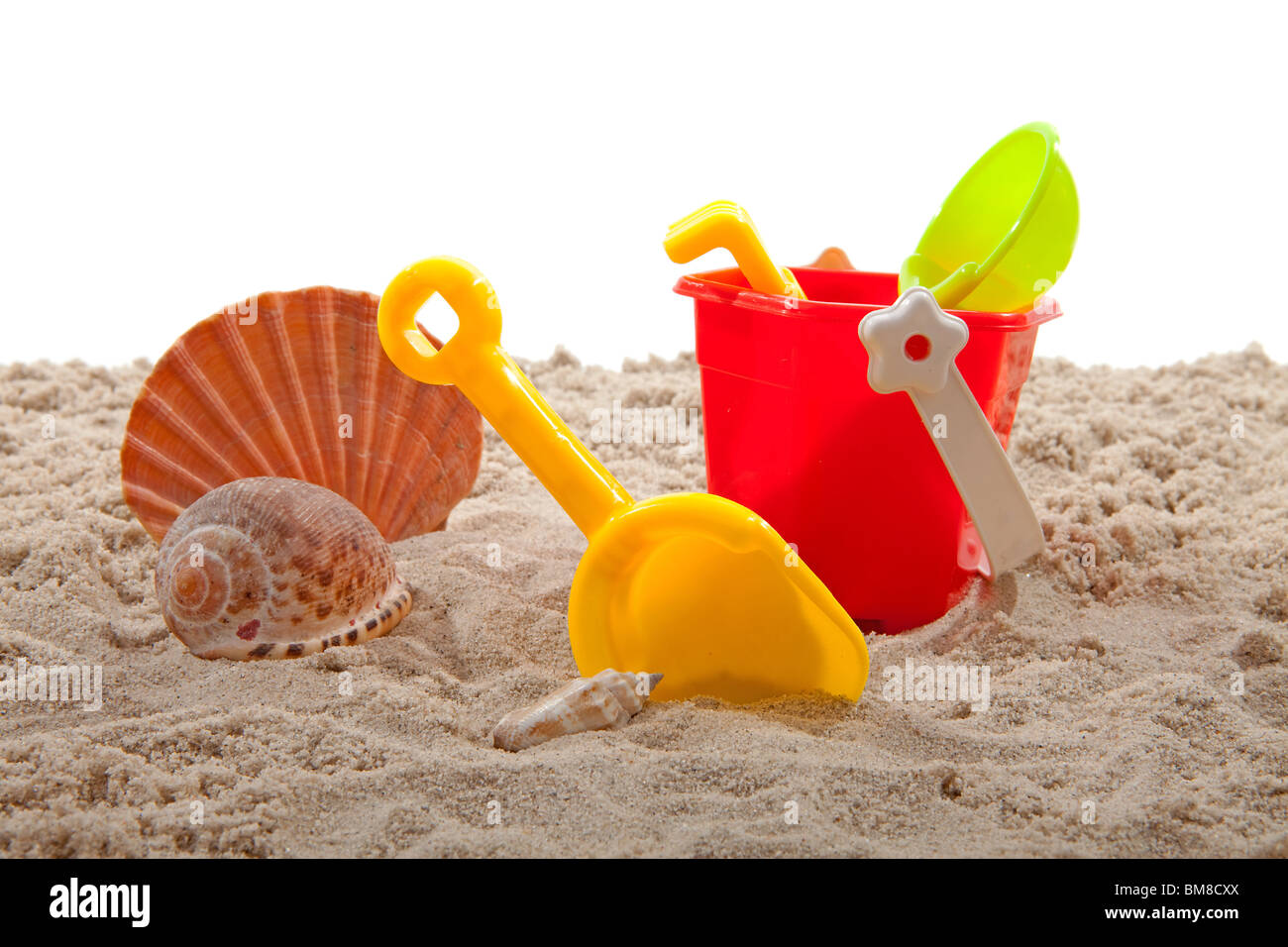 Kunststoff-Spielzeug für den Strand und Shell auf Sand auf weißem Hintergrund Stockfoto