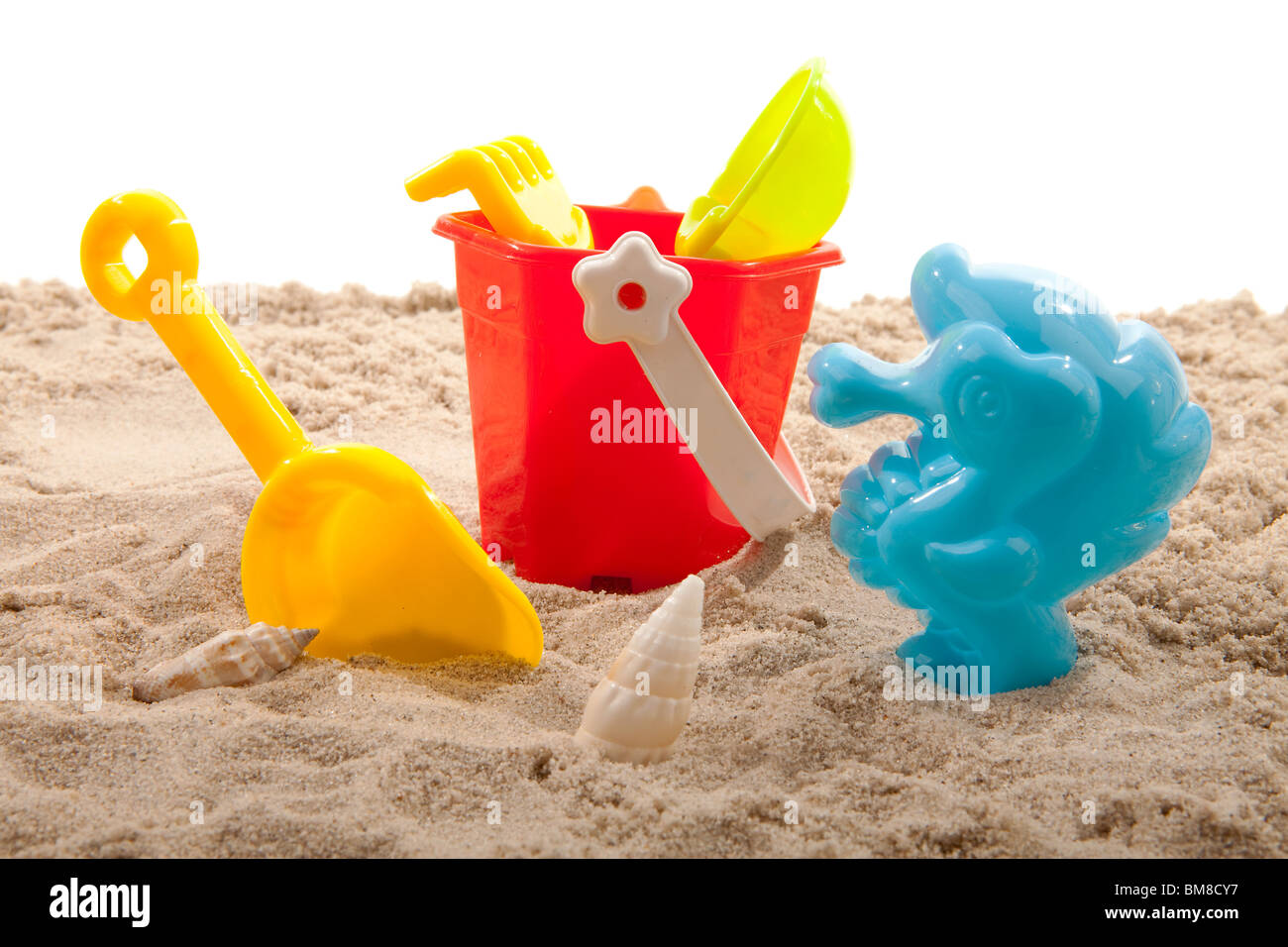 Kunststoff-Spielzeug für Strand auf Sand auf weißem Hintergrund Stockfoto