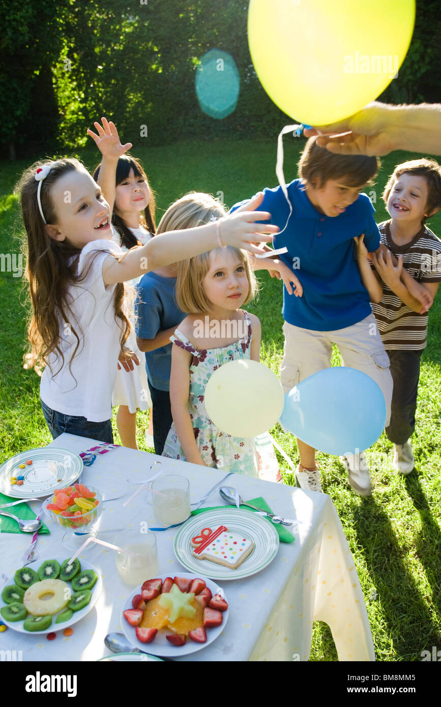 Verteilen von Luftballons am Kindergeburtstag Stockfoto