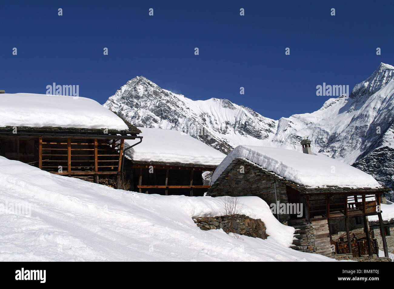 Alphütten, bedeckt mit Pulverschnee in Alagna Valsesia Dorf, Monterosa Ski Resort, Italien Stockfoto
