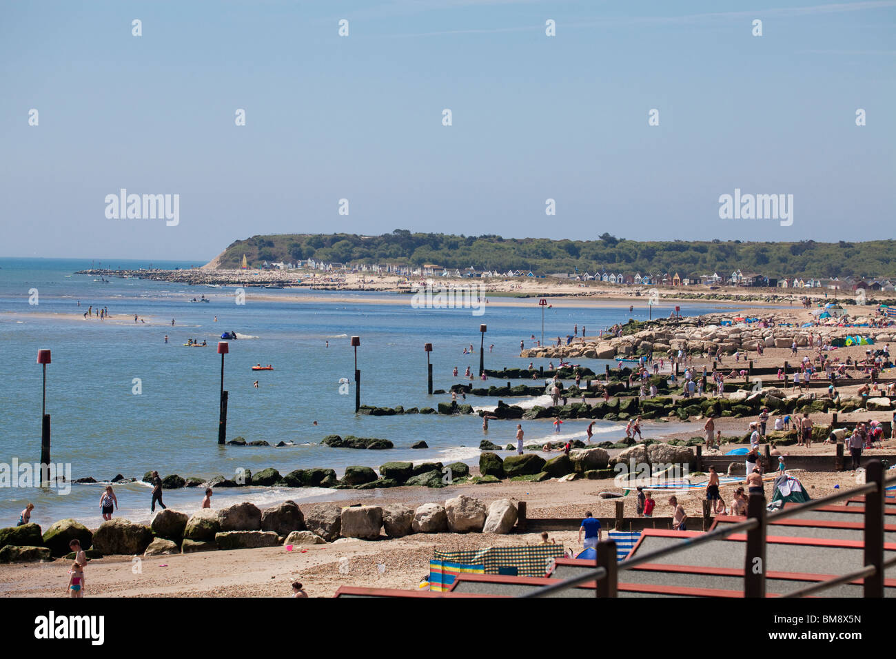 Rowes von Holz- und Rock Buhnen, Küstenschutzes mit roten Marker Pole am Mudeford Strand Stockfoto