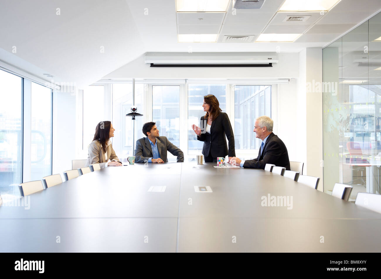 Weibliche Führungskraft im Gespräch mit einer Gruppe von Menschen in einem Büromeeting Stockfoto