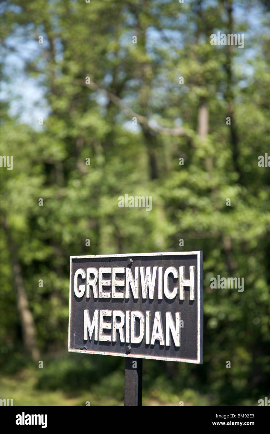 Greenwich-Meridian Schild ein grüner Baum Laub Hintergrund Stockfoto