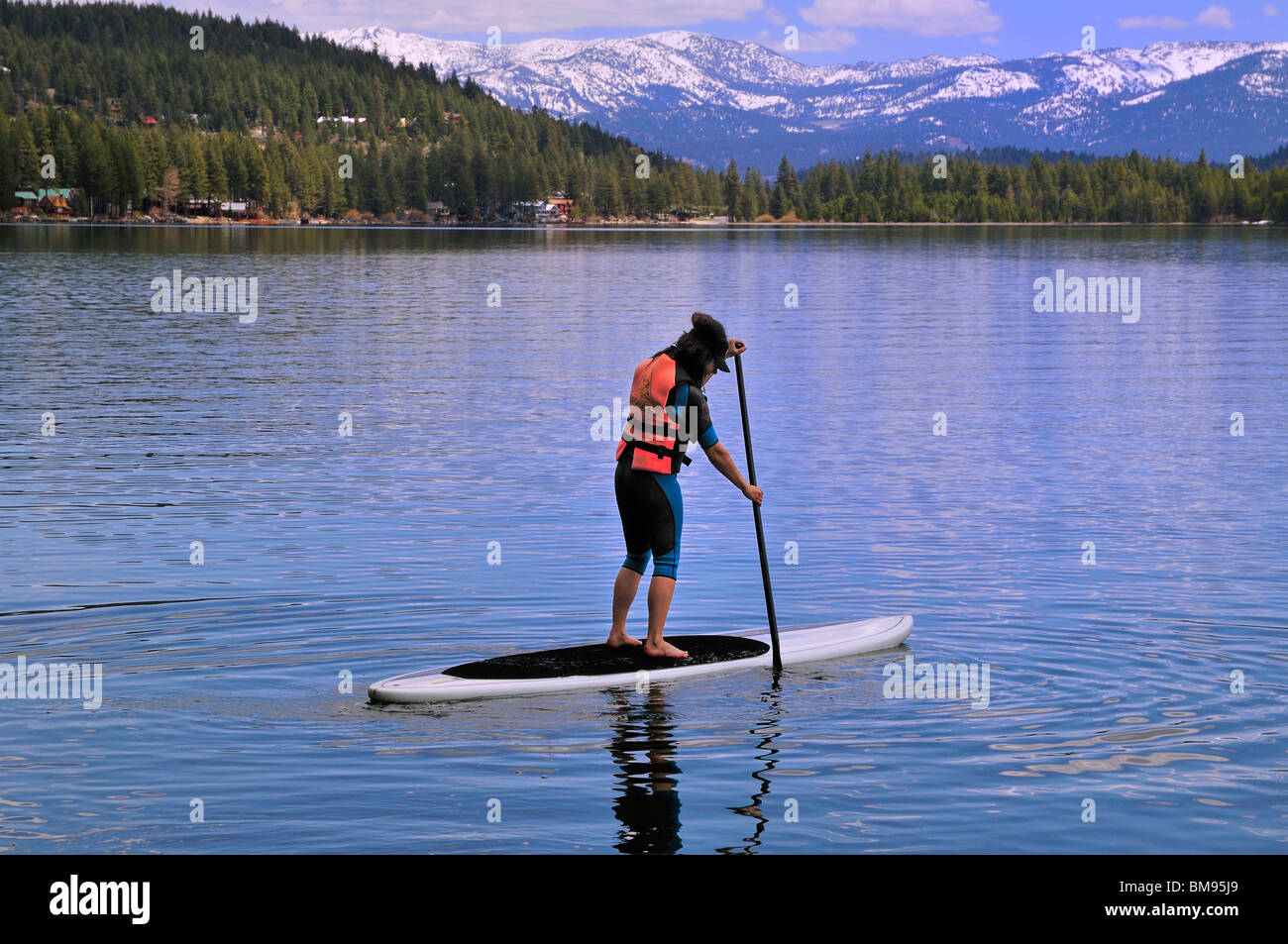 Eine Paddel-Boarder kreuzt Donner Lake, Truckee, Kalifornien Stockfoto