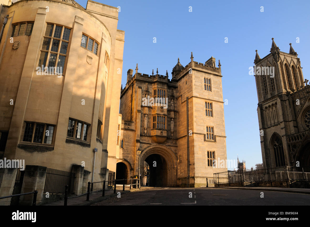 Mittelalterliche Torhaus, Bristol Cathedral und Teil des Rückens der Zentralbibliothek auf Bristol College grün mit blauem Himmel Stockfoto