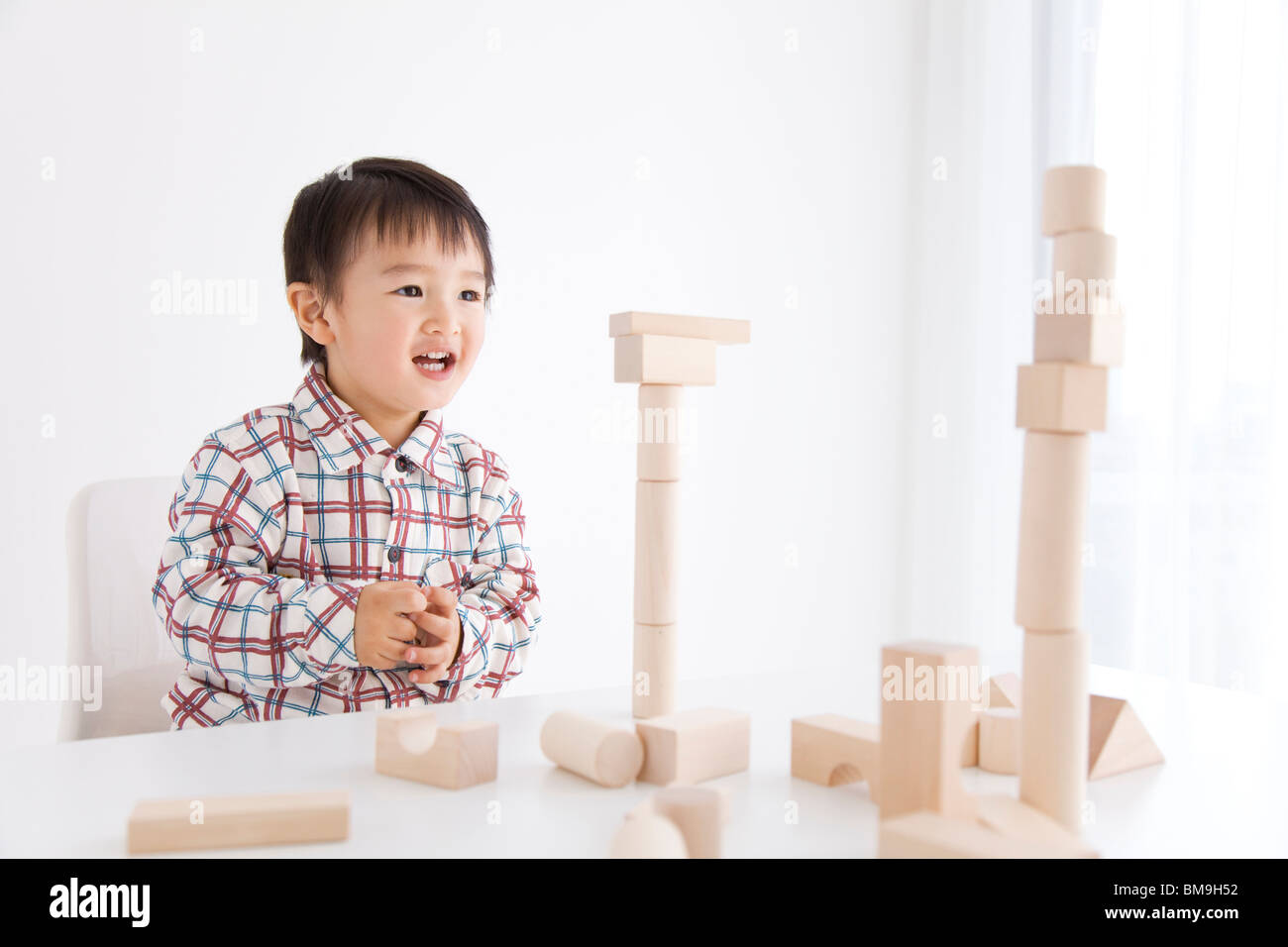 Junge spielt mit Holz- Baustein Stockfoto