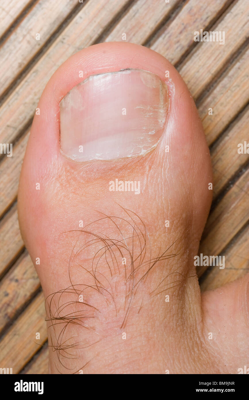 Foto von einer großen Zehe auf einer hölzernen Matte Stockfoto