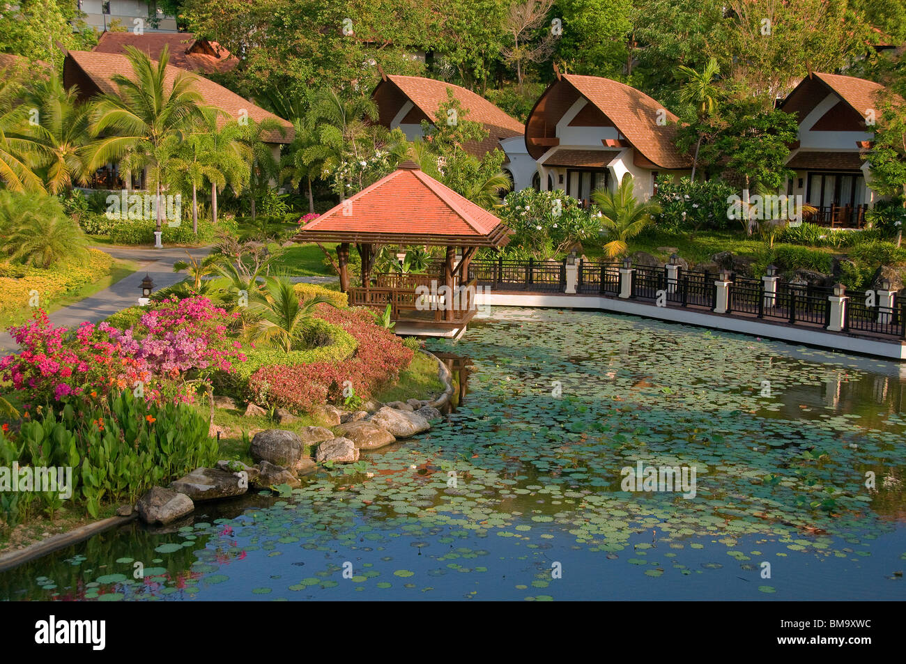 Das Rawi Warin Resort & Spa hat mehrere schöne Zimmer und Villen rund um einen großen, schönen mäandernden Gartenteich. Stockfoto