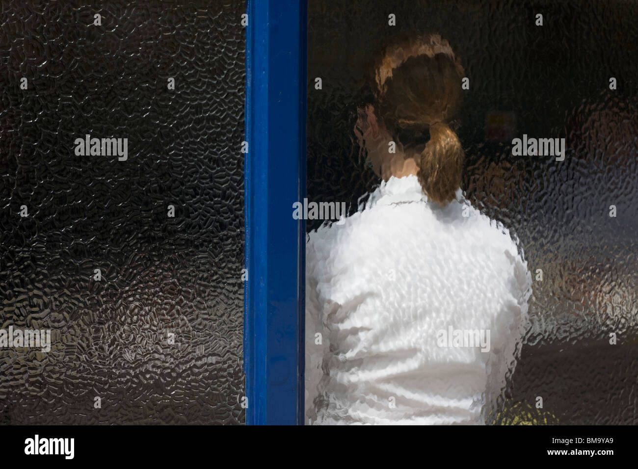 Eine Dame Kellnerin wartet mittags Business, gesehen durch das mattierte Fenster Sweetings Fischrestaurant, City of London. Stockfoto
