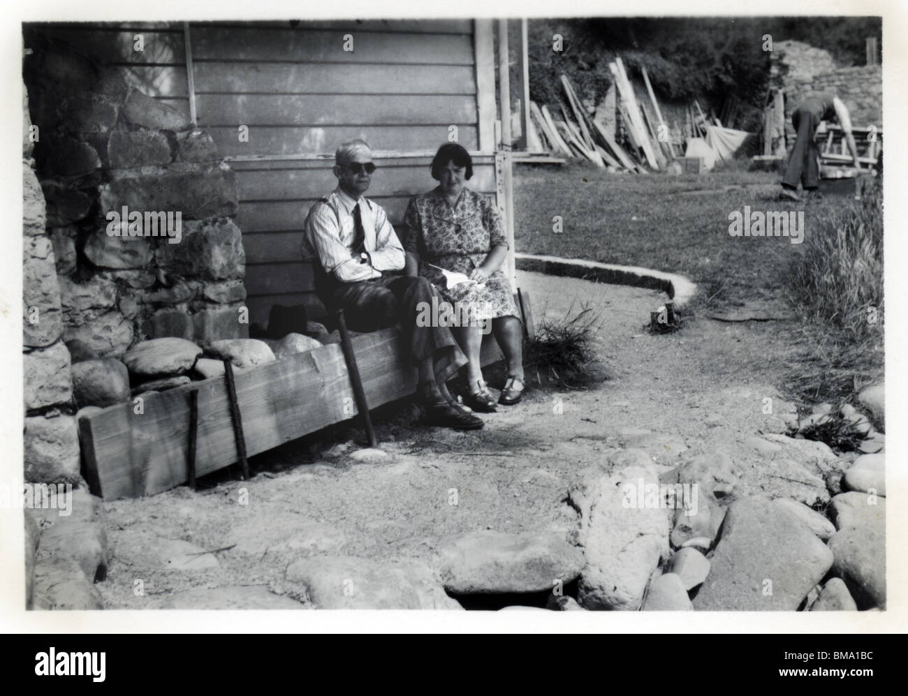 Archiv Bild: Altes Ehepaar sitzen unter einem Balkon (1940) Stockfoto