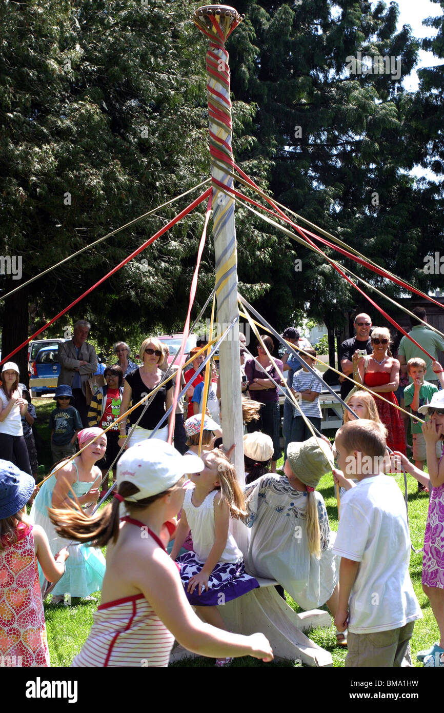 Kinder tanzen den Maibaum auf einem Schulfest Sommer Stockfoto