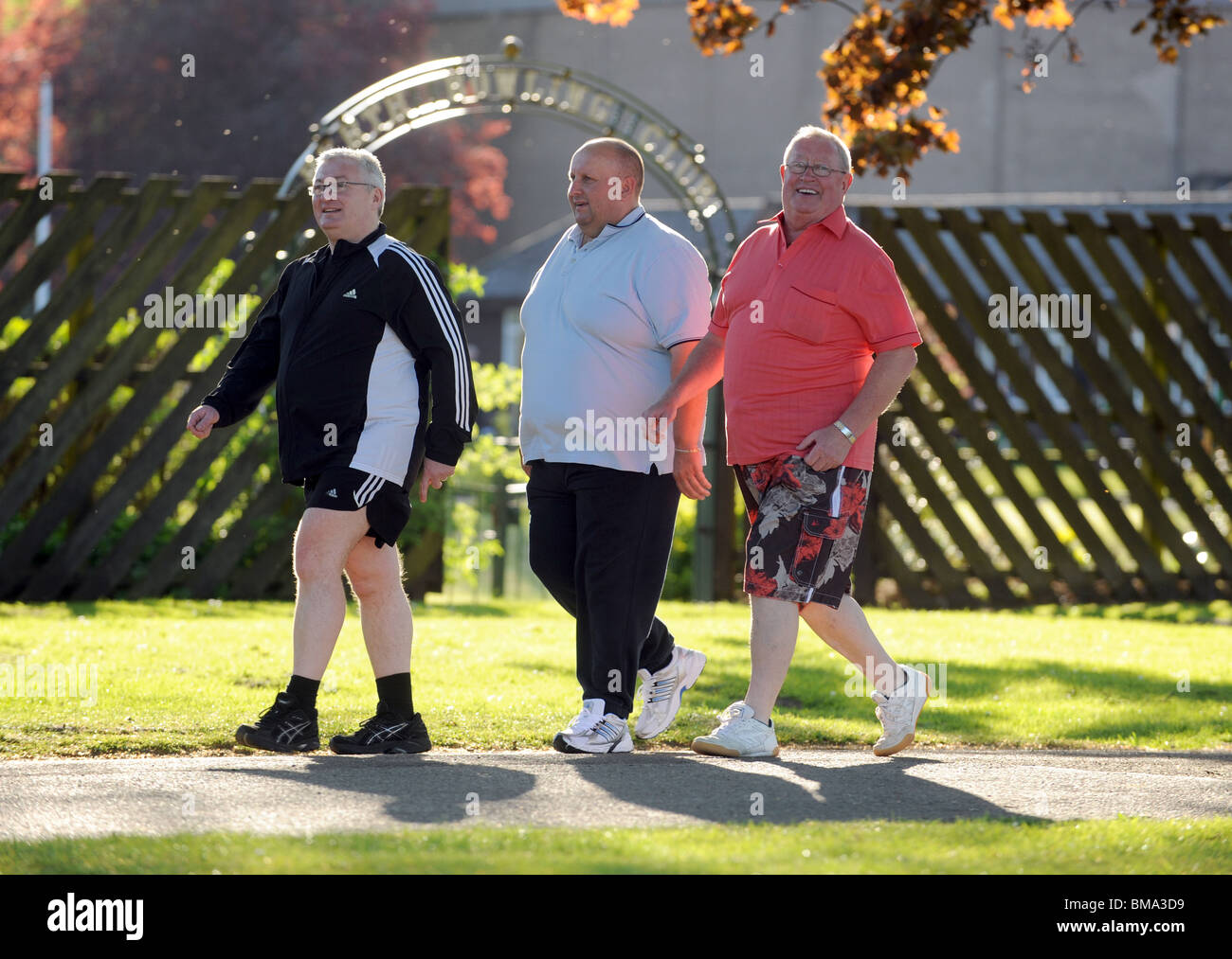Drei dicke Männer zu Fuß durch den park Stockfoto