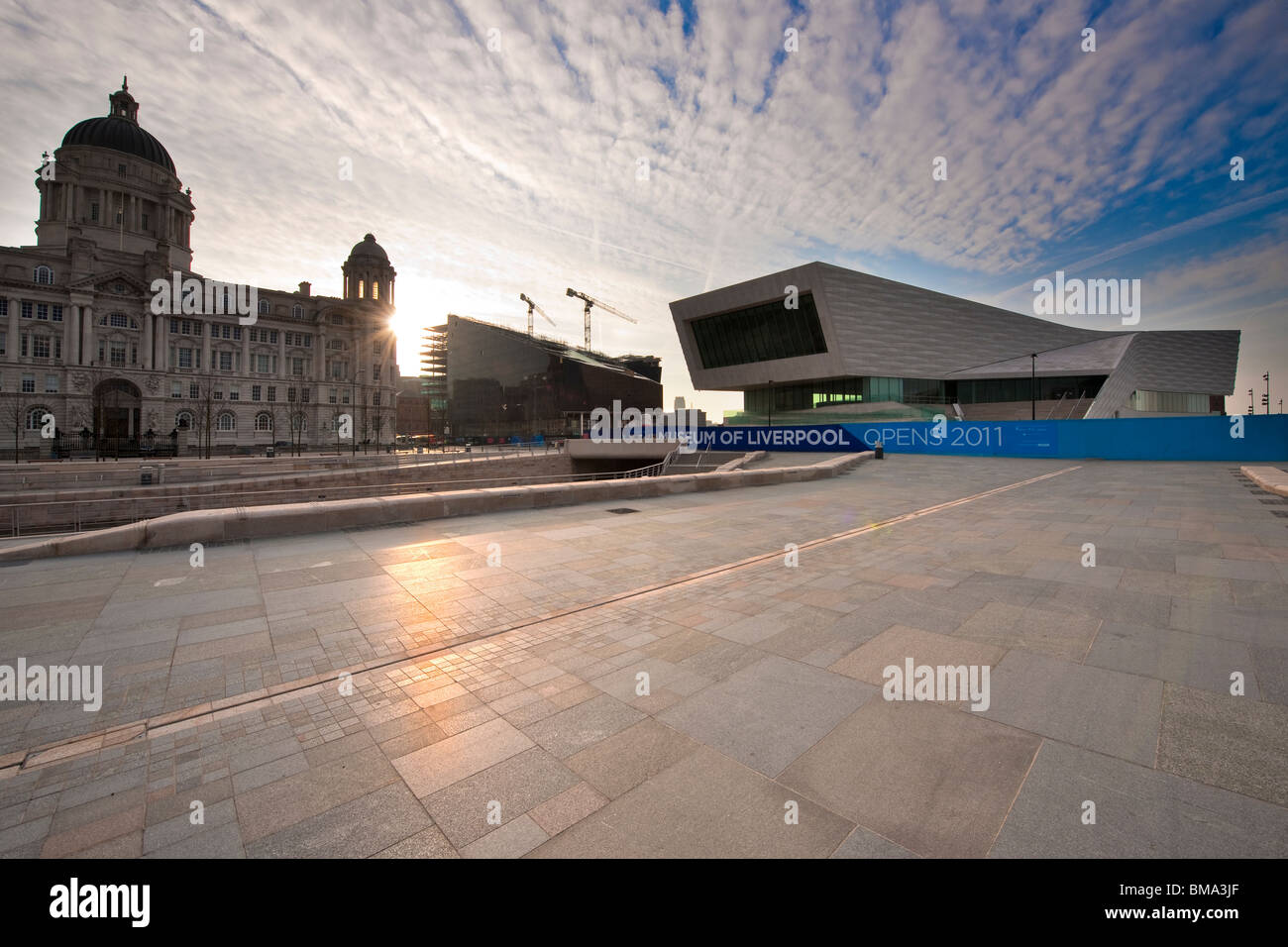 Sonnenaufgang zwischen The Port of Liverpool Building, Mann-Insel und das neue Museum of Liverpool am historischen Hafen von Liverpool. Stockfoto