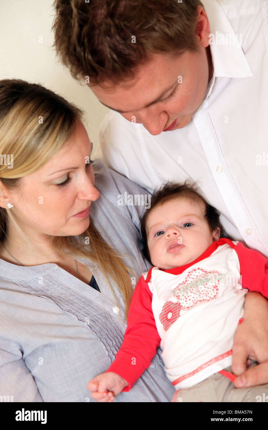 Junge Familie mit einem Baby. Eltern halten Sie ihr Kind liebevoll in seine Arme Stockfoto