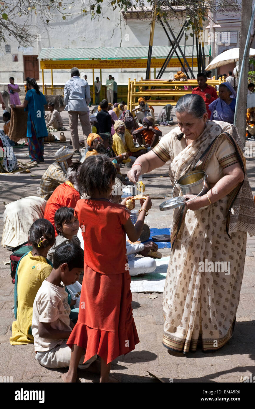 Frau, die Nahrung, die Bettler geben. Orchha. Indien Stockfoto