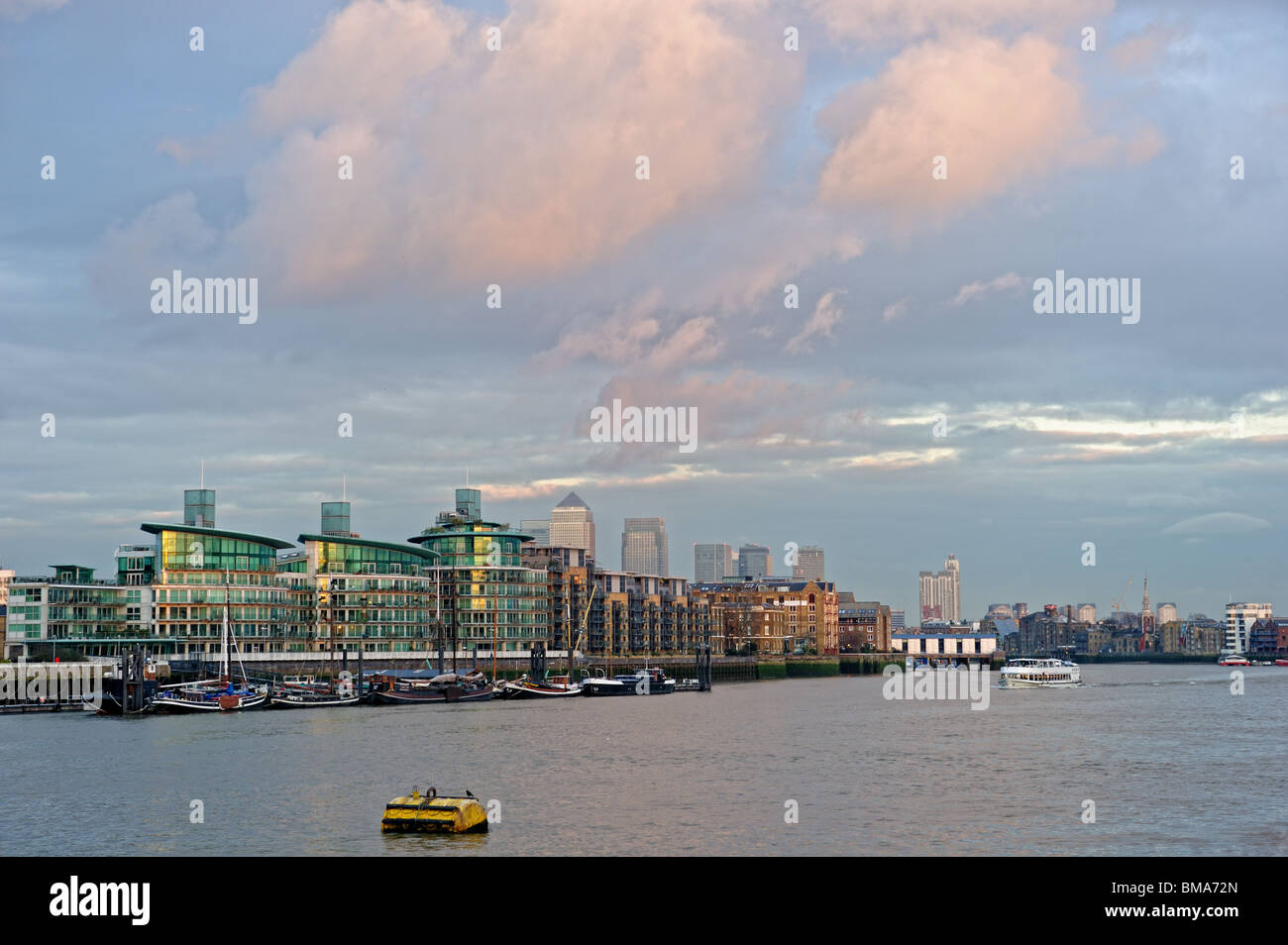 Typische Luxus Themse am Flussufer Entwicklung, Wapping, Eastend, London, England, UK, mit Canary Wharf im Hintergrund Stockfoto