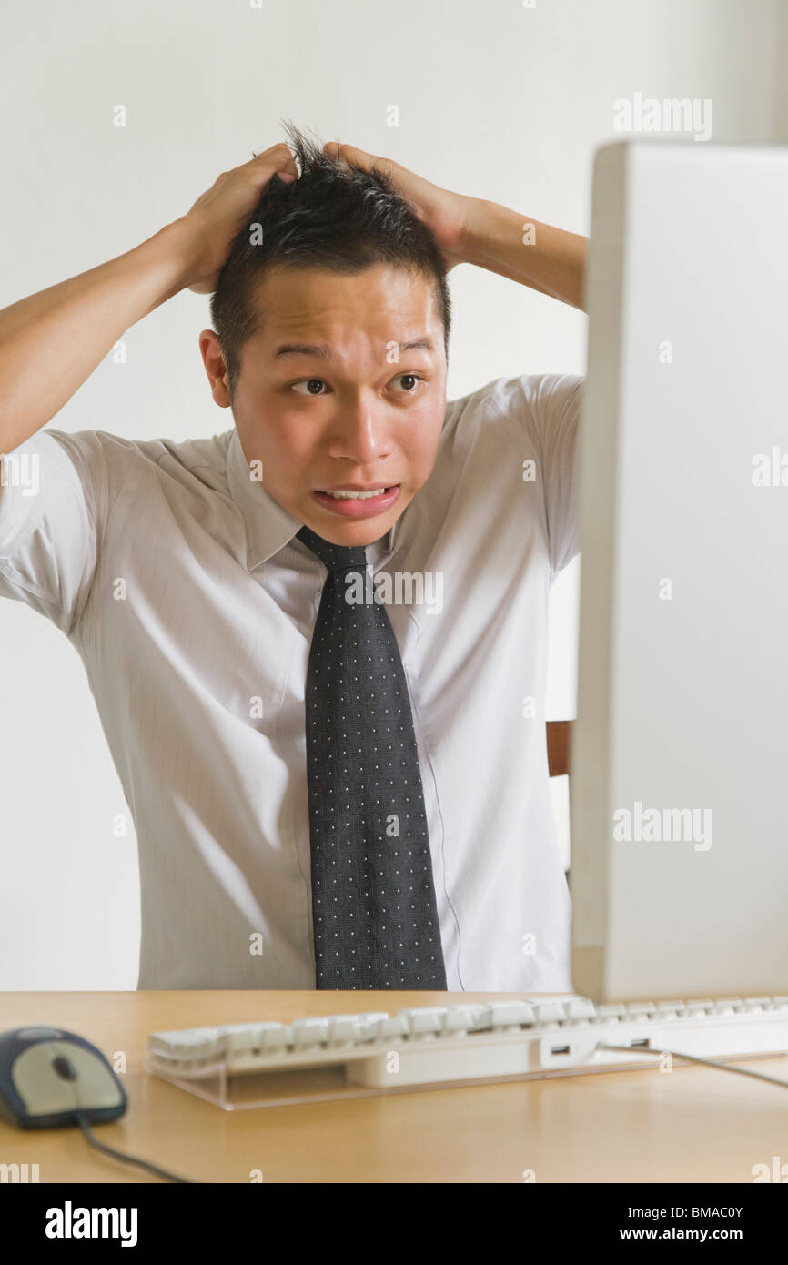 Geschäftsmann, seine Haare vor Desktop Computer Stockfoto