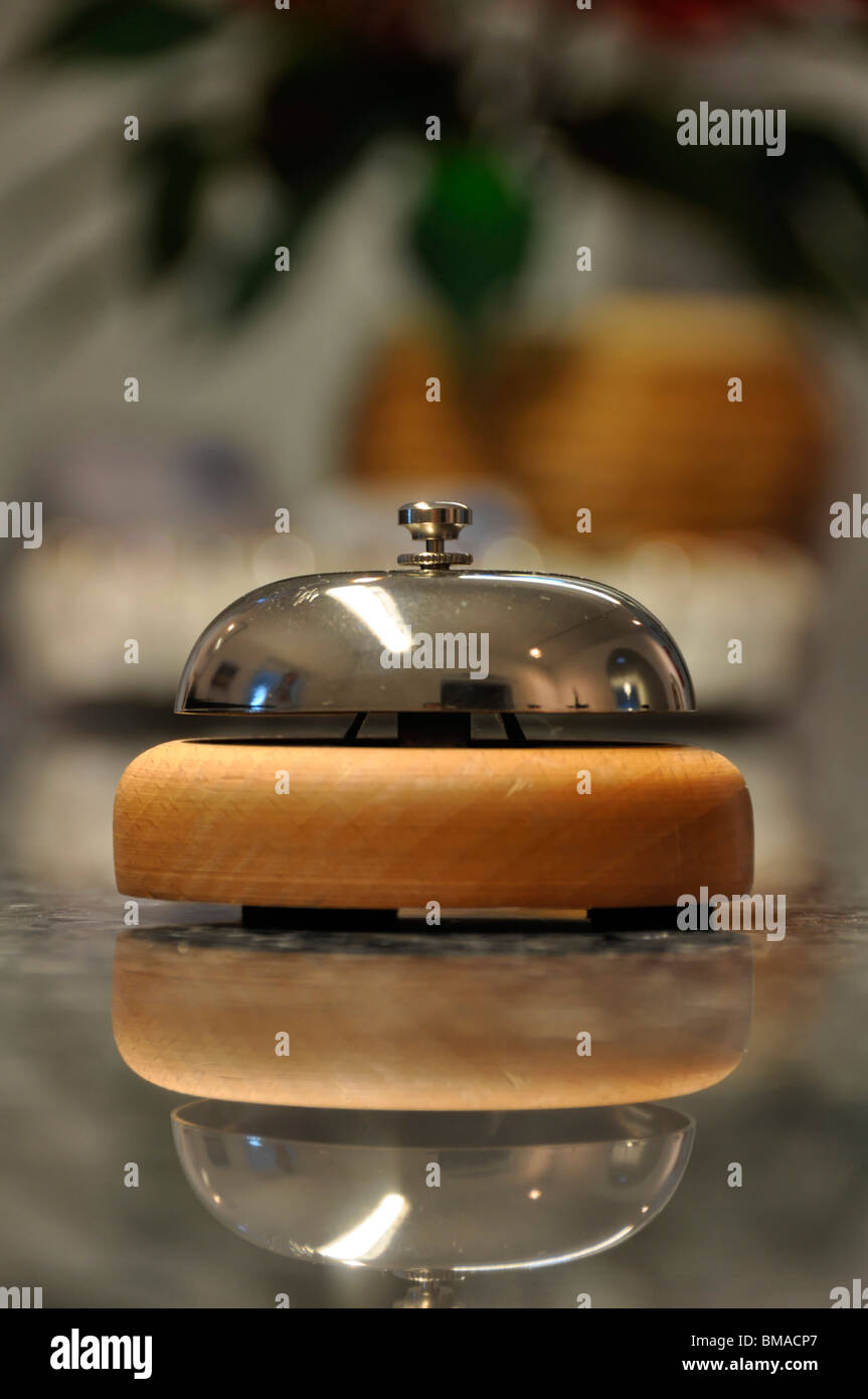 Detail-Aufnahme einer Dienst-Glocke befindet sich auf einer Hotelrezeption mit verschwommenen Details in den Hintergrund und die Reflexion über Marmor Stockfoto