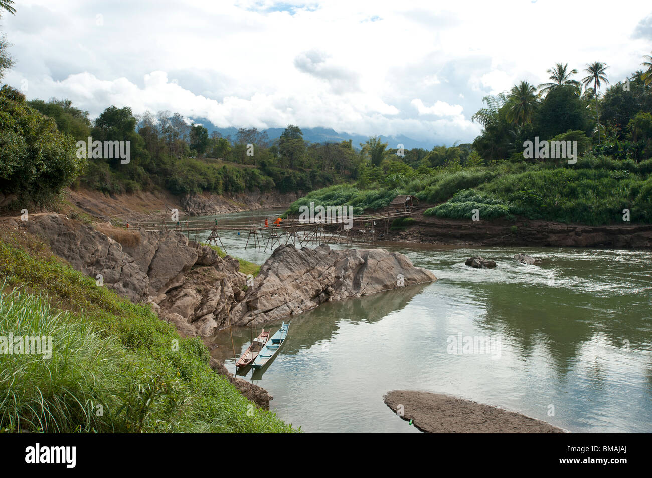 Eine Bambusbrücke überspannt den Fluss Nam Khan am Zusammenfluss des Mekong-Flusses in Luang Prabang Laos Stockfoto