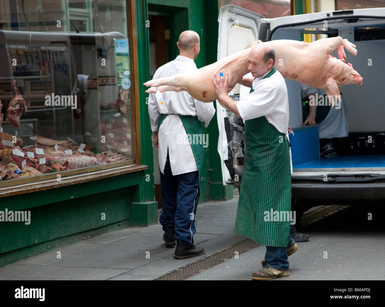Metzger mit Schwein in der Straße, Bad Stockfoto