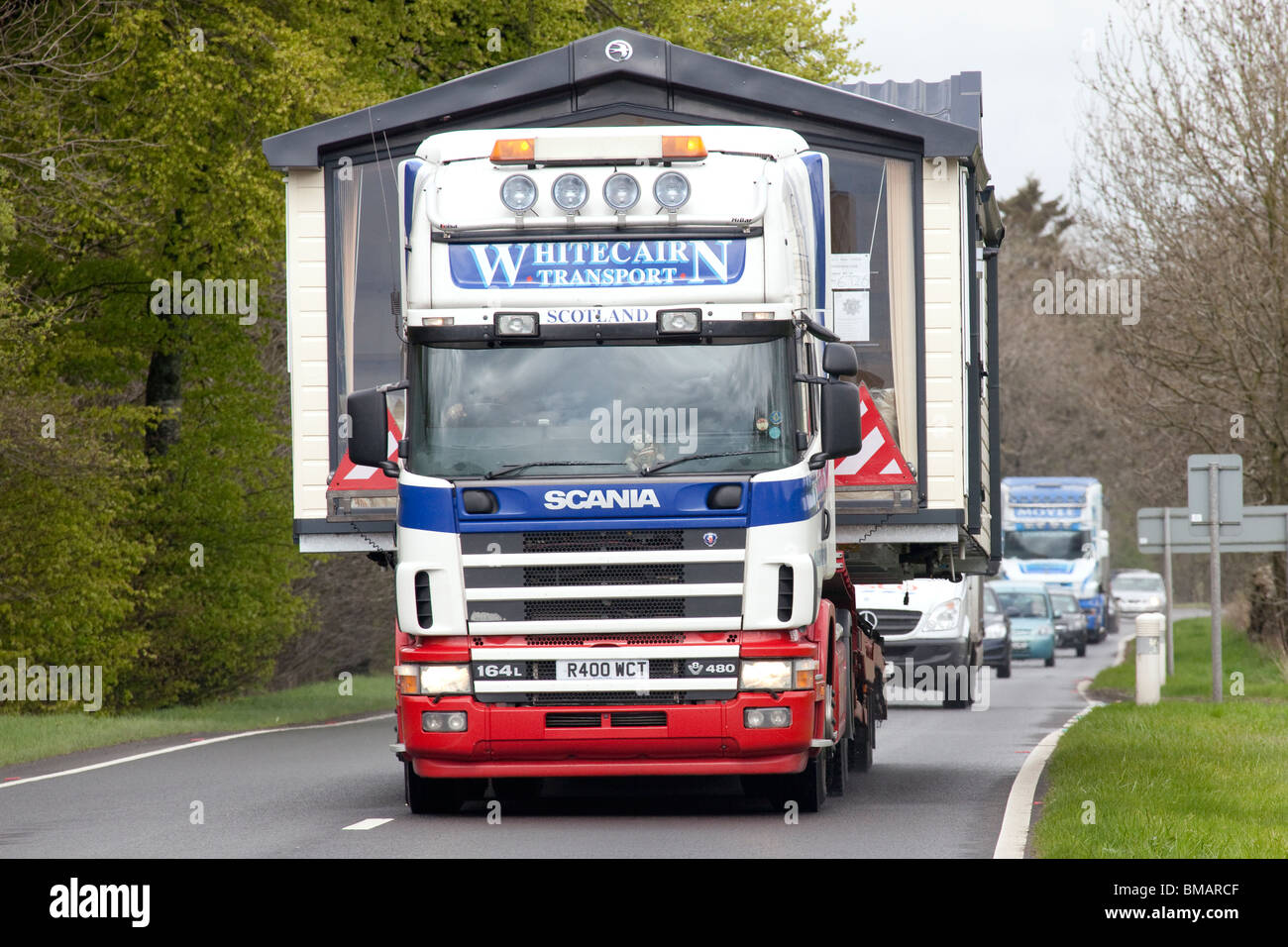 Eine breite oder abnorme Belastung auf der Rückseite eines LKW Reisen entlang der Straße A75 mit Warteschlange des Verkehrs hinter UK Stockfoto