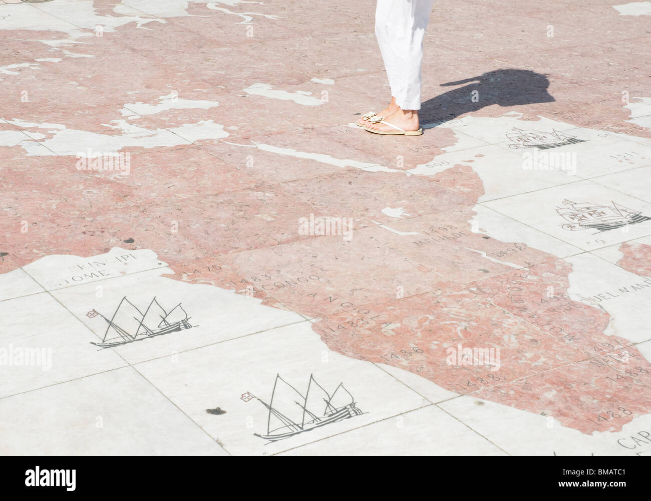 Besucher auf dem Bürgersteig Kompass vor dem Denkmal der Entdeckungen in Lissabon werfen ihre Schatten über der Karte Gesicht. Stockfoto